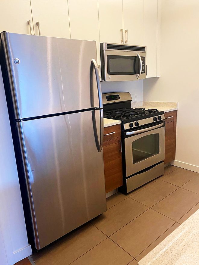 A finished tile kitchen with a clean refrigerator and range