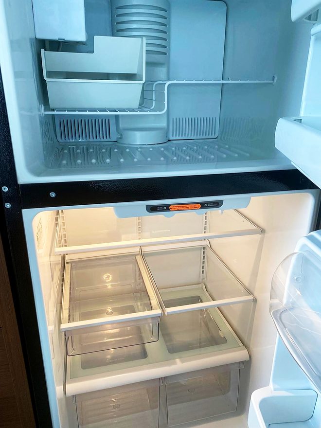 A clean refrigerator and freezer interior with the doors open